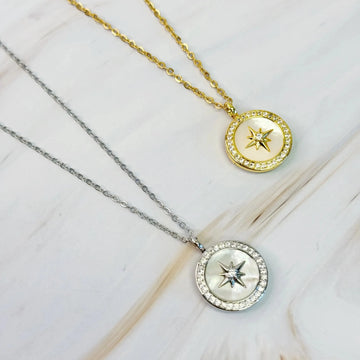 Shine Compass Open Locket Necklace i gull og sølv på marmorbakgrunn